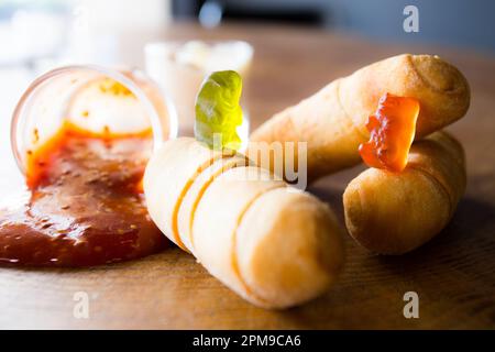 Gummibären spielen auf einem Esstisch mit venezolanischen tequeños. Stockfoto