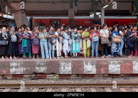 Eine Gruppe überwiegend weiblicher Pendler, die einen Bahnsteig am Dadar Station in Mumbai, Indien, einem der geschäftigsten Bahnhöfe der Stadt, überqueren Stockfoto