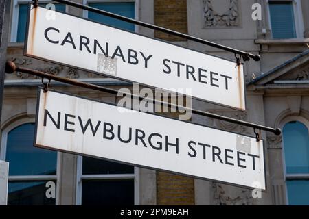 Ein Schild zur Carnaby Street und Newburgh Street. Berühmtes Touristen- und Einkaufsziel in Westminster, London, Großbritannien. Stockfoto