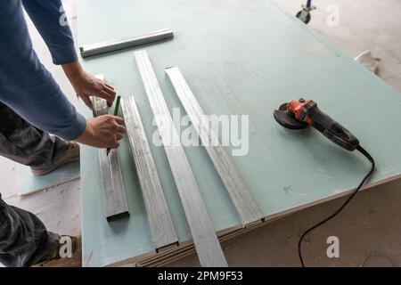 Drywall Installers. Men holding a gypsum board figured cut Stockfoto