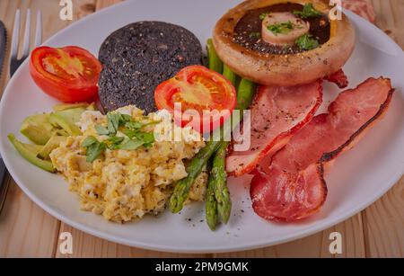 Gesundes warmes Frühstück auf einem weißen Teller auf einem Holztisch. Stockfoto