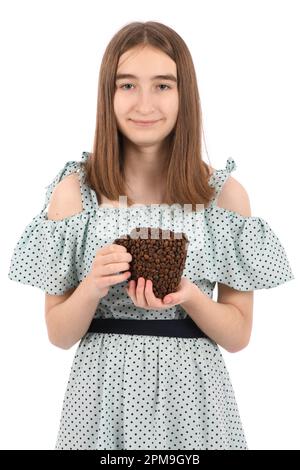 Ein junges, hübsches Mädchen in einem gepunkteten Kleid mit einer Tasse Kaffee, isoliert auf weißem Hintergrund. Die Tasse besteht aus Kaffeebohnen. Hochauflösendes Pho Stockfoto