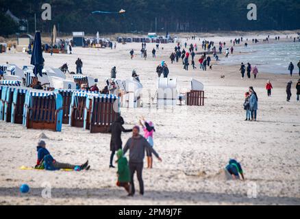 Binz, Deutschland. 12. April 2023. Touristen wandern bei sonnigem Wetter am Ostseestrand des Ostseeraums Binz auf der Insel Rügen. Kredit: Stefan Sauer/dpa/Alamy Live News Stockfoto