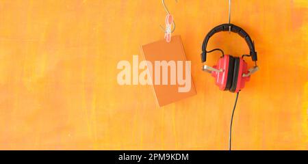 Hörbuchkonzept mit Büchern und alten roten Kopfhörern, Panoramablick, kostenloser Kopierbereich Stockfoto