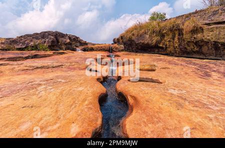 Ein Bach, der einen Pfad durch dickes Gestein ausgräbt. Foto aufgenommen im Kharmih Park, Sohra/Cherrapunjee, Meghalaya, Indien. Stockfoto