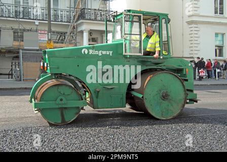 Wiederbelebungsgeschäft für Ringway Highway ein Fahrer von Rollermaschinen im Einsatz verdichtet neue Asphaltflächen in South Kensington London England UK Stockfoto