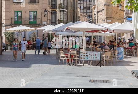 Cáceres Spanien - 09 12 2021 Uhr: Saint John Square oder Plaza de San Juan, mit mehreren Personen und Familien, Terrassen mit Bars und Restaurants im Freien, gesellig Stockfoto