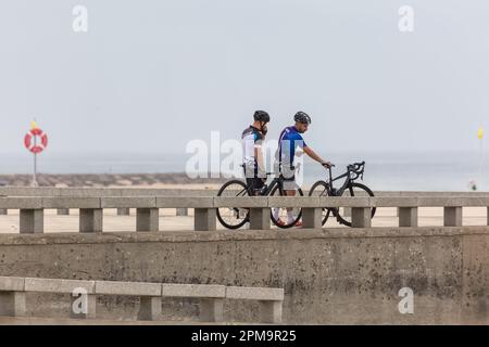 Torreira Aveiro Portugal - 08 07 2022 : Blick auf zwei männliche Radfahrer, die stehen, ihre Profifahrräder schnappen, sich ausruhen und den Strand und das s genießen Stockfoto