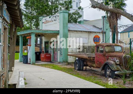 KENNER, LA, USA - 31. MÄRZ 2023: Nachbildung einer Kleinstadt aus den 30er Jahren mit Retro-Tankstelle und einem rostigen alten 1930er Ford Pickup-Truck im Heritage Park Stockfoto