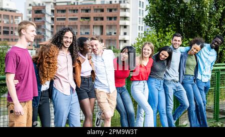 Glückliche Gruppe von multirassischen jungen Freunden, vielfältige Leute, die draußen vor der Kamera lächeln, internationale Gemeinschaft und fröhliche Menschen Stockfoto