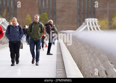 Die Menschen gehen über die Millennium Bridge in London, während starke Winde über die Hauptstadt ziehen. Bilddatum: Mittwoch, 12. April 2023. Stockfoto