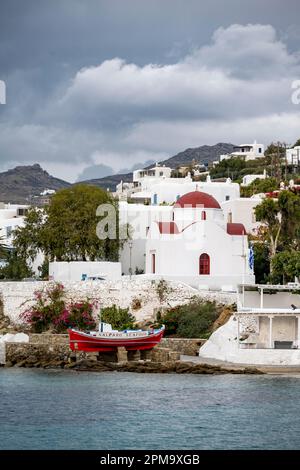 Fischerboot und kleine griechisch-orthodoxe weiße Kirche mit rotem Dach, Heilige Kirche von Rodon und Amaranto, alter Hafen von Mykonos, Chora, Mykonos-Stadt, Mykonos Stockfoto