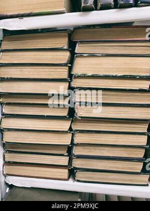 12.04.2023, Kemerovo, Russland. In den Regalen der Schulbibliothek sind viele Bücher. Keine neuen, alten Bücher in der öffentlichen Bibliothek. Hintergrund von Stockfoto