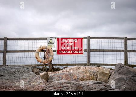 "Baden und Paddeln gefährlich" -Schild mit Rettungsboot Stockfoto