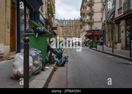 Überfließende Mülltonnen auf der Straße von Paris, Frankreich während des Rentenreformstreiks. 24. März 2023. Stockfoto