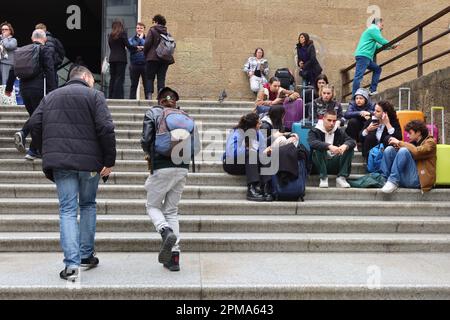 Florenz, Italien. 12. April 2023. Touristen sitzen am 12 2023. April vor dem Bahnhof Santa Maria Novella in Florenz, Italien. Da Italien während der Osterferien eine außergewöhnliche Zahl von Touristen aus der ganzen Welt verzeichnete, sprachen die italienischen Behörden von "Übertourismus" als ein Phänomen, das Kunststädte und Naturschauplätze im Land gefährden könnte. (Foto: Elisa Gestri/Sipa USA) Kredit: SIPA USA/Alamy Live News Stockfoto