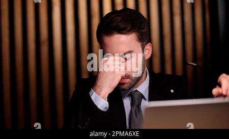 Geschäftsmann mit Händen hinter dem Kopf, der in einem komfortablen Büro ruht. Stockfoto