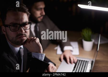 Zwei Mitarbeiter mittleren Alters arbeiten an einem Schreibtisch in einem Büro. Stockfoto