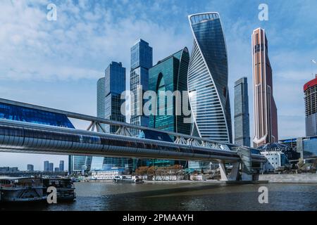 Moskau, Russland - 06. April 2021: Fußgängerbrücke Bagration auf dem Moskauer Fluss mit Wolkenkratzern Moskauer Stadt im Hintergrund Stockfoto