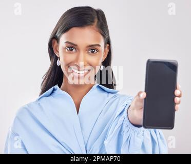 Telefon, Studio und Porträt einer indischen Frau mit Lächeln für Werbung, Werbung und Mockup-Leinwand. Weißer Hintergrund, glücklich und mit dem Gesicht eines Mädchens Stockfoto