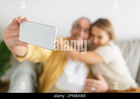 Ältere Paare, die Zeit verbringen, Spaß haben und Selfie auf dem Smartphone machen, Online-Unterhaltung genießen, konzentrieren sich auf das Telefon Stockfoto