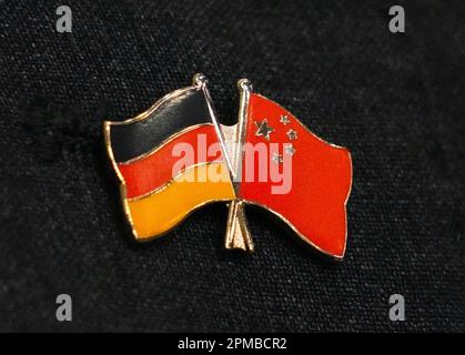 12. April 2023, Brandenburg, Schönefeld: Eine Nadel in Form der Flaggen Chinas und Deutschlands ist am Revers eines Delegationsmitglieds befestigt. Außenministerin Baerbock (Bündnis 90/die Grünen) beginnt heute Abend ihre Reise mit einer Delegation von Politikern und Journalisten, zunächst nach China und dann nach Südkorea und Japan. Foto: Soeren Stache/dpa Stockfoto