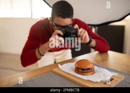 Ein kulinarischer Fotograf, der Fotos von köstlichen Hamburgern macht Stockfoto