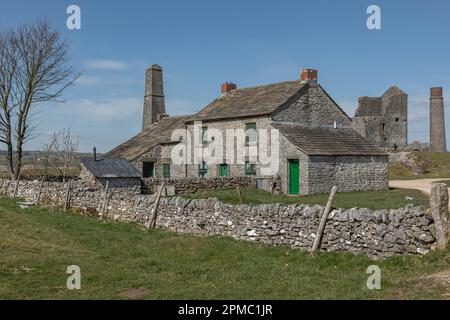 Ein altes Steinhaus im Peak District an einem Tag im Frühling vor einem hellblauen Himmel Stockfoto