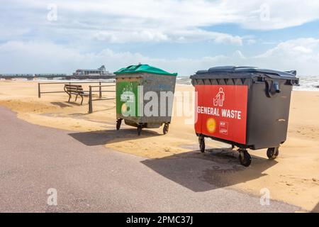 Große kommerzielle Mülltonnen für allgemeine Abfälle und Recycling am Rande eines Fußwegs am Bournemouth Beach in Dorset, Großbritannien Stockfoto