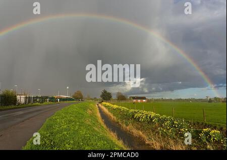 Ein Regenbogenhimmel über einem Haus und Feld mit Wyberton West Road in die Ferne Stockfoto