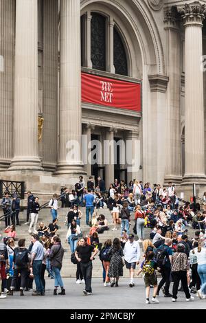 An einem sonnigen Frühlingsnachmittag im Jahr 2023 in New York City, USA, versammeln sich auf den vorderen Stufen des Metropolitan Museum of Art große Besuchermassen Stockfoto