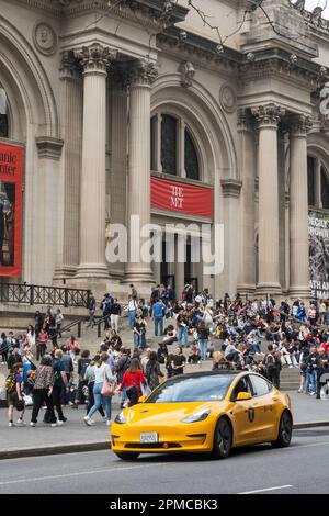 An einem sonnigen Frühlingsnachmittag im Jahr 2023 in New York City, USA, versammeln sich auf den vorderen Stufen des Metropolitan Museum of Art große Besuchermassen Stockfoto