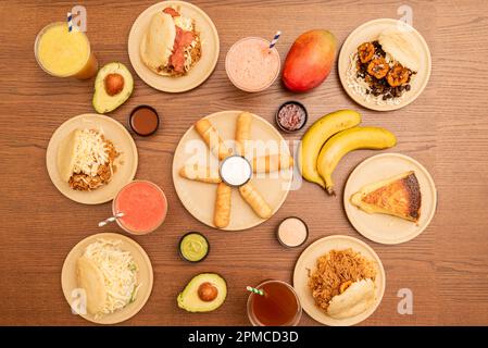 Set venezolanischer Fast-Food-Gerichte mit vielen verschiedenen Arepas auf einem Holztisch Stockfoto