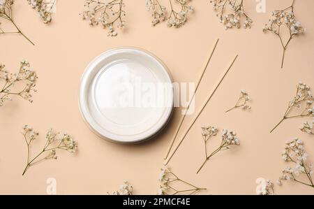 Öffnen Sie die leere Nudelschüssel mit einem Paar Holzstäbchen auf beigefarbenem Hintergrund, Draufsicht Stockfoto