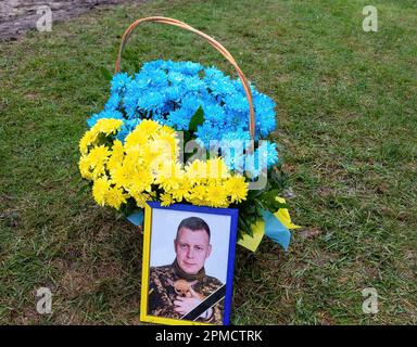 Ein Foto von Evgeny Yakovlev, 42, einem Soldaten, der von den russischen Streitkräften an der Ostukrainischen Front in einem Kampf auf dem Lisove Friedhof in Kiew getötet wurde. Auf dem Lisove Friedhof sind die meisten der gefallenen Armeeangehörigen aus Kiew begraben. Da die Invasion der Ukraine in vollem Umfang durch die russischen Streitkräfte andauert, verursacht der Kampf im Osten der Ukraine eine sehr hohe Zahl von Opfern, obwohl die genauen Zahlen unbekannt sind. Die Ukraine bereitet sich auf eine Frühjahrsoffensive zur Rückeroberung des von Russland besetzten Landes vor. Stockfoto