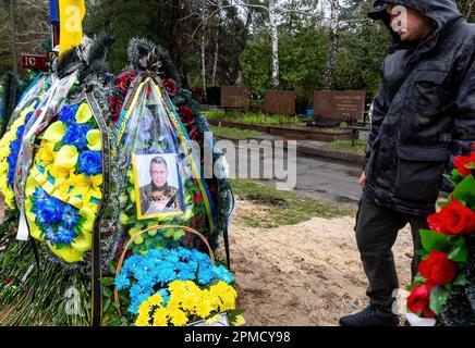12. April 2023, Kiew, Ukraine: Ein Freund schenkt Respekt bei der Beerdigung von Evgeny Yakovlev, 42, einem Soldaten, der von russischen Streitkräften an der Ostukrainischen Front in einem Kampf auf dem Lisove Friedhof getötet wurde. Auf dem Lisove Friedhof sind die meisten der gefallenen Armeeangehörigen aus Kiew begraben. Da die Invasion der Ukraine in vollem Umfang durch die russischen Streitkräfte andauert, verursacht der Kampf im Osten der Ukraine eine sehr hohe Zahl von Opfern, obwohl die genauen Zahlen unbekannt sind. Die Ukraine bereitet sich auf eine Frühjahrsoffensive zur Rückeroberung des von Russland besetzten Landes vor. (Kreditbild: © Dominika Zarzycka/SOPA Images via ZUMA Press Wire) EDITORIA Stockfoto