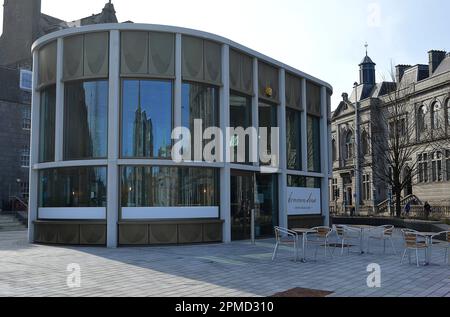 ABERDEEN, SCHOTTLAND - 11. APRIL 2023: Einer der neuen Pavillons, die im Rahmen der mehrmillionenschweren Renovierung der Union Terrace Gardens erbaut wurden. Die Fenster von Schoolhill und Marischal Square spiegeln sich wider. Stockfoto