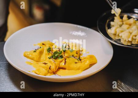 Auf diesem Foto sehen wir einen Teller hausgemachter italienischer Pasta mit einer köstlichen Sauce. Die Pasta ist perfekt gekocht und hat eine wunderschöne goldene Farbe. Stockfoto