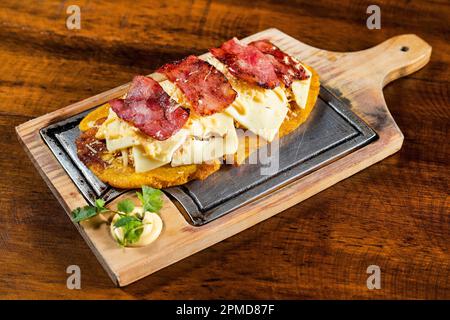 Grüner Plantain Patacon mit gehacktem Huhn, Käse und Speck - kolumbianisches Street Food Stockfoto