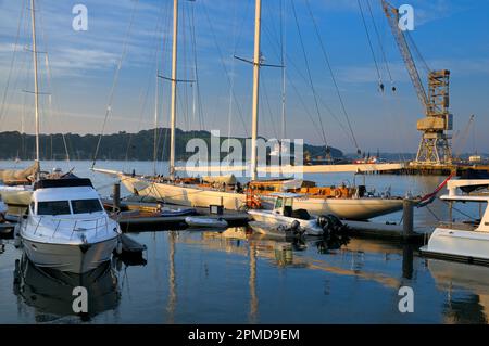 Sanftes, goldenes Sonnenlicht auf einem Segelboot, das in Falmouth Harbour, Cornwall, England, Großbritannien, vor Anker liegt Stockfoto