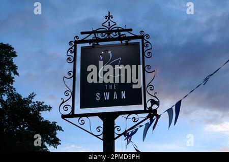 Ein kunstvoll verziertes Metallschild in der Abenddämmerung vor dem Swan, einem modernen Pub und Restaurant im Cotswold-Dorf Broadway, Cotswolds, Worcestershire, England, Großbritannien Stockfoto
