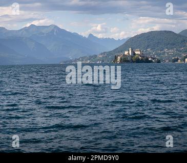 Ein Orta-See mit einer Burg auf St. Julius Island und Bergen im Hintergrund Stockfoto