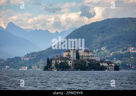 Ein Orta-See mit einer Burg auf St. Julius Island und Bergen im Hintergrund Stockfoto