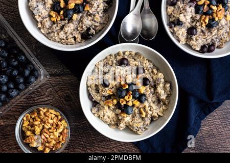 Heidelbeeren-Chia-Haferflocken garniert mit Walnüssen: Gesundes Haferflocken-Frühstück mit Heidelbeeren, Walnüssen und Chiasamen Stockfoto