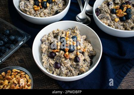 Heidelbeeren-Chia-Haferflocken garniert mit Walnüssen: Gesundes Haferflocken-Frühstück mit Heidelbeeren, Walnüssen und Chiasamen Stockfoto