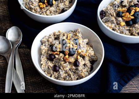 Heidelbeeren-Chia-Haferflocken garniert mit Walnüssen: Gesundes Haferflocken-Frühstück mit Heidelbeeren, Walnüssen und Chiasamen Stockfoto