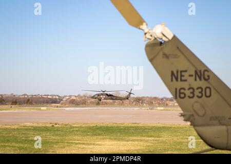 Soldaten der Nationalgarde der Nebraska Army starten in einem UH-60 Blackhawk Helikopter von der Army Aviation Support Facility in Lincoln, Nebraska, am 12. April 2023 nach Cherry County, Nebraska, um örtliche Ersthelfer und Notfallmanager bei der Bekämpfung der fortlaufenden Waldbrände zu unterstützen. Das war einer von zwei UH-60 Blackhawk Hubschraubern, die an diesem Morgen geschickt wurden, um mehrere Waldbrände im ganzen Staat zu bekämpfen. Der zweite Hubschrauber fuhr nach Jefferson County, Nebraska. Insgesamt wurden ab 10:00 Uhr 32 Soldaten der Nationalgarde von Nebraska und Flugzeuge - Luft- und Bodenpersonal - zur Unterstützung der Feuerwehr gerufen April 12 Stockfoto