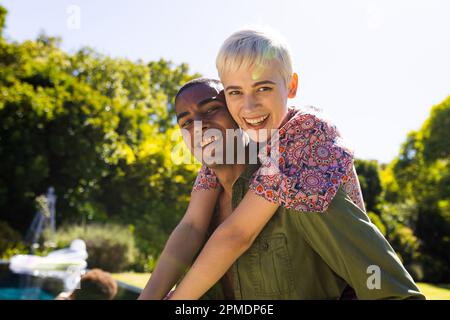 Porträt eines glücklichen, vielfältigen Paares, das im Garten lächelt Stockfoto