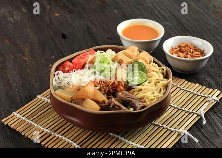 Soto Mie Bogor. Traditionelle sudanesische Rindernudelsuppe mit Frühlingsrolle, Kohl und Tomaten. Street Food aus Bogor, West Java, Indonesien. Stockfoto