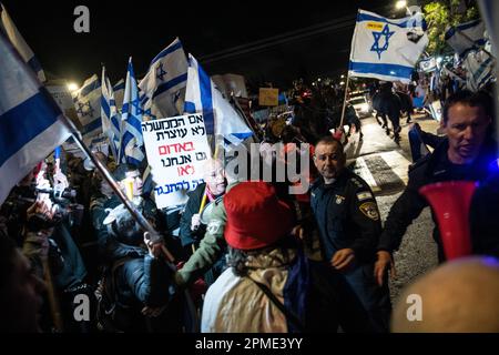 Israel. 12. April 2023. Israelische Polizeibeamte und montierte Polizisten drängen Demonstranten gegen die Reform von der Straße vor einer Mimouna-Zeremonie in Hadera zurück, an der Premierminister Benjamin Netanjahu teilnahm. Auf dem Schild steht: "Wenn die Regierung nicht bei Rot anhält, dann machen wir es auch nicht! Wir müssen uns wehren.“ April 12. 2023. (Matan Golan/Sipa USA) Guthaben: SIPA USA/Alamy Live News Stockfoto